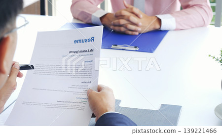 Businessman job interview by human resource HR officer interviwing, talk new employee shaking hands in office with smiling face. HR Manager interview check resume, face to face. Job Interview Concept Businessman job interview by human resource HR officer interviwing, talk new employee shaking hands in office with smiling face. HR Manager interview check resume, face to face. Job Interview Concept 139221466