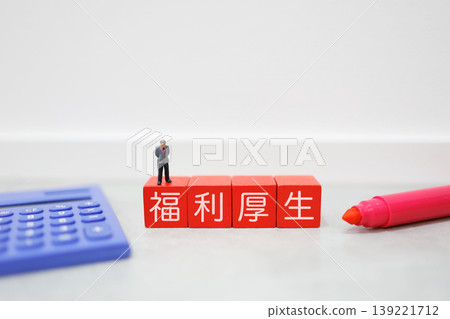 員工福利。計算器和迷你商人。紅色方塊上的字母。 員工福利。計算器和迷你商人。紅色方塊上的字母。 139221712