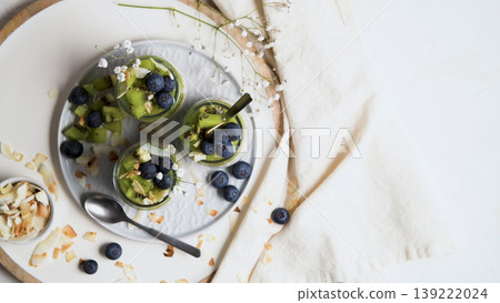 Top View of Chia Seed Pudding with Kiwi and Blueberries in Glass Jars 139222024