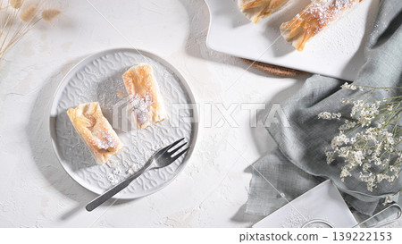 Top View of Phyllo Pastry Rolls Sprinkled with Powdered Sugar on White Plates Top View of Phyllo Pastry Rolls Sprinkled with Powdered Sugar on White Plates 139222153