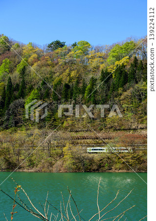 北上線列車沿著岩手縣錦湖鬱鬱蔥蔥、生機勃勃的秋色湖岸飛馳而過。 北上線列車沿著岩手縣錦湖鬱鬱蔥蔥、生機勃勃的秋色湖岸飛馳而過。 139224112