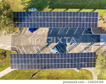 Photovoltaic canopy over parking area producing renewable electricity. Solar panels provide shade for vehicles while generating sustainable energy integrated into city infrastructure. 139224184