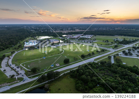 People playing soccer game on illuminated public stadium at sunset. Active way of life concept People playing soccer game on illuminated public stadium at sunset. Active way of life concept 139224188