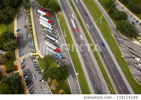 Parking rest area for cargo tractor-trailers near American interstate freeway. Resting place during interstate goods hauling in USA. Parking rest area for cargo tractor-trailers near American interstate freeway. Resting place during interstate goods hauling in USA. 139224189