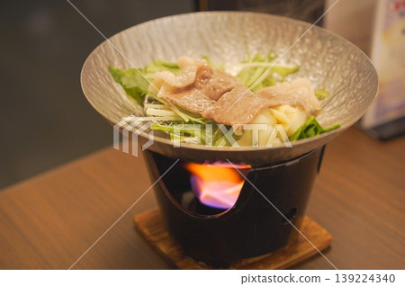 用固體燃料烹調的單人份火鍋。 用固體燃料烹調的單人份火鍋。 139224340