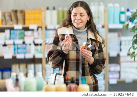Young woman chooses nail polish at pharmacy Young woman chooses nail polish at pharmacy 139224648