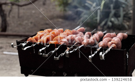 Juicy skewers of meat and vegetables grilling over charcoal. Juicy skewers of meat and vegetables grilling over charcoal. 139224658