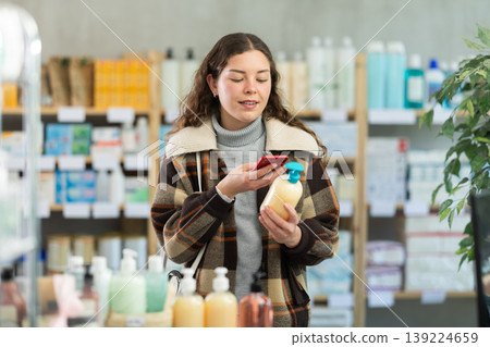 Young woman scanning qr code of hand soap Young woman scanning qr code of hand soap 139224659
