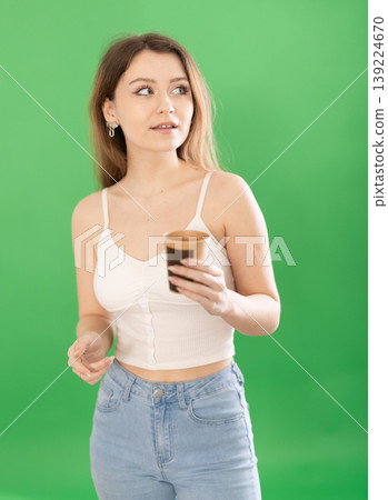 European woman enjoying coffee on a green background European woman enjoying coffee on a green background 139224670