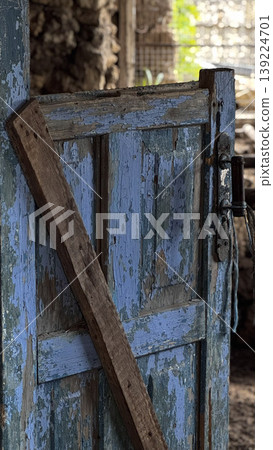 Close-up of an old, weathered blue wooden door. Close-up of an old, weathered blue wooden door. 139224701