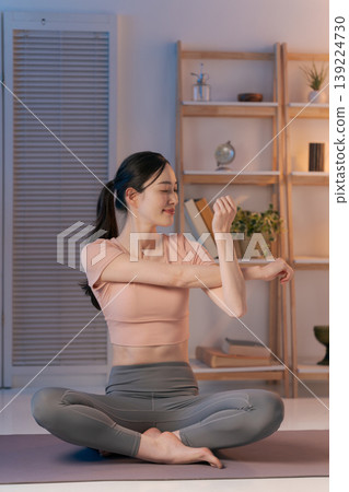 A woman who plays yoga in the room 139224730