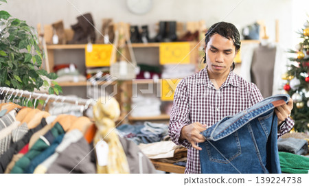 In chain shop, Indonesian man choose jeans, X mas shopping In chain shop, Indonesian man choose jeans, X mas shopping 139224738