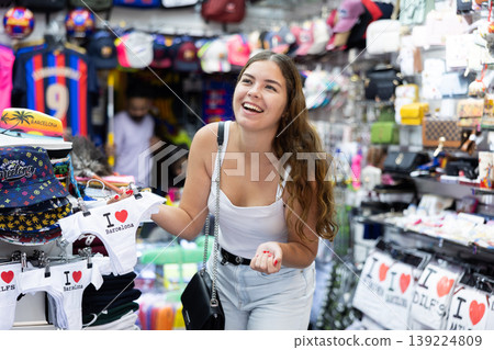 Joyful young woman viewing underwear with Barcelona marking Joyful young woman viewing underwear with Barcelona marking 139224809