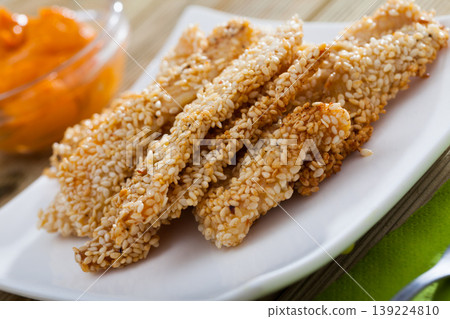 Chicken strips in sesame with sauce 139224810