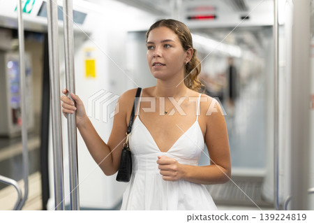 Calm young girl standing on wagon travelling by subway 139224819