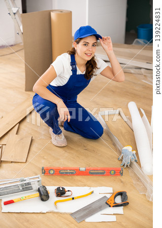 Woman construction worker setting wooden laminate board on floor Woman construction worker setting wooden laminate board on floor 139224831