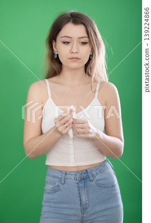 Sad young woman crying in front of green screen Sad young woman crying in front of green screen 139224866