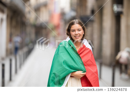 Young woman wrapped in Italian flag on city street Young woman wrapped in Italian flag on city street 139224878