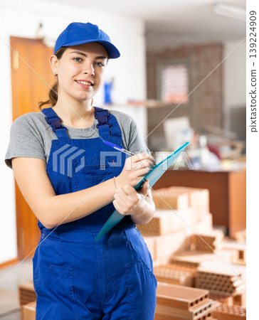 Young woman construction worker standing inside apartment Young woman construction worker standing inside apartment 139224909