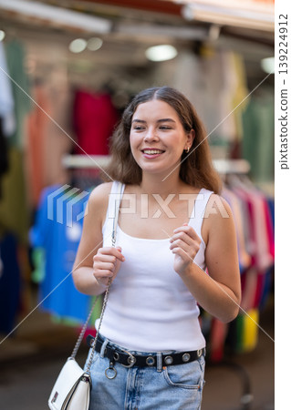 Girl looks at contents of clothes shop window assortment 139224912