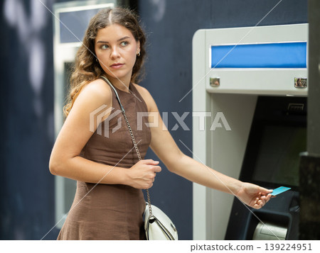 Young woman standing near ATM Young woman standing near ATM 139224951