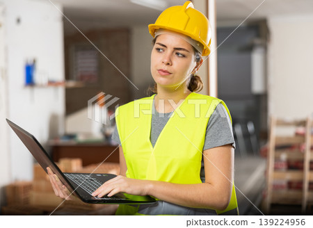 Woman with laptop on indoor construction site Woman with laptop on indoor construction site 139224956