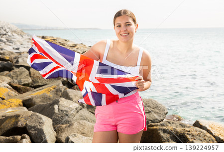 Young woman on coast posing with UK flag Young woman on coast posing with UK flag 139224957