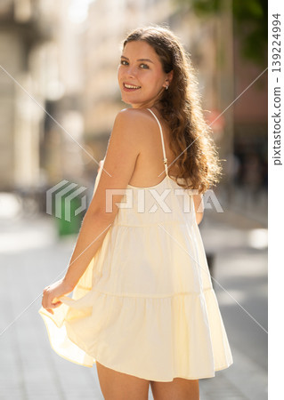 Young woman walks along city street Young woman walks along city street 139224994