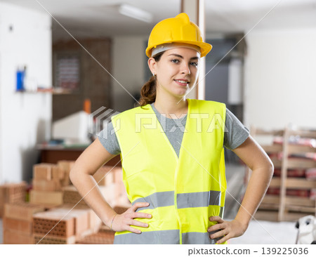 Young woman construction worker standing inside apartment Young woman construction worker standing inside apartment 139225036