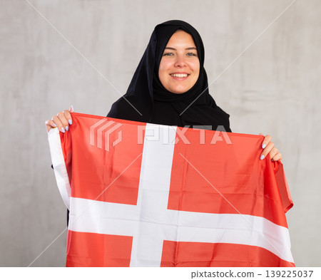 Happy young woman dressed in traditional islamic clothes with danish flag Happy young woman dressed in traditional islamic clothes with danish flag 139225037
