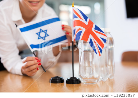 Office coordinator setting flags of Israel and United Kingdom on table 139225057
