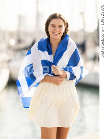 Young woman wrapped in Greek flag at port Young woman wrapped in Greek flag at port 139225070
