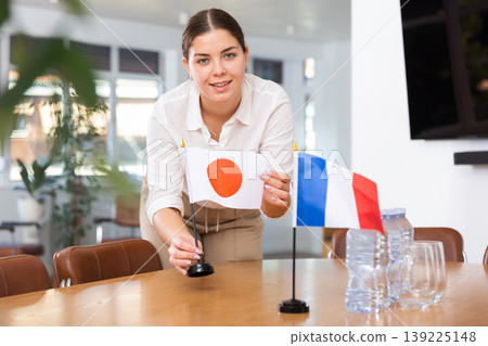 Employee of delegation prepares negotiating table - sets up flag of Japan and France Employee of delegation prepares negotiating table - sets up flag of Japan and France 139225148