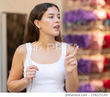 Girl looks at contents of shop window assortment Girl looks at contents of shop window assortment 139225149