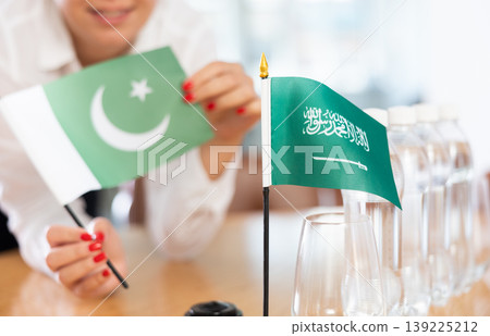 Flags of Pakistan and Saudi Arabia stand on negotiating table in office 139225212