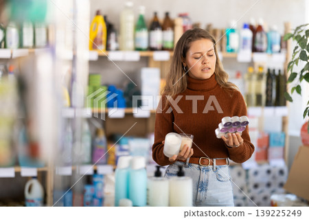 Young woman choosing scented candles in store Young woman choosing scented candles in store 139225249