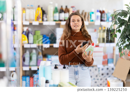 Young woman scanning QR-code on dishwashing liquid in supermarket Young woman scanning QR-code on dishwashing liquid in supermarket 139225250