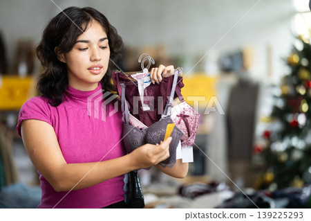 Asian woman choosing a bra on the background of the Christmas tree Asian woman choosing a bra on the background of the Christmas tree 139225293