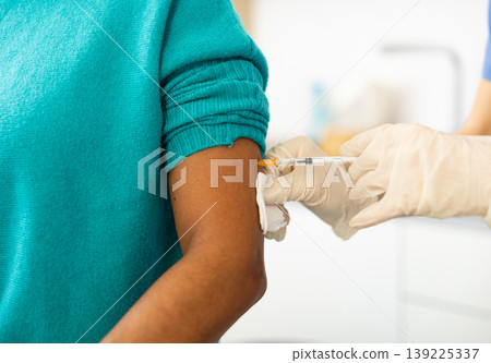 Doctor giving vaccine shot to patient arm Doctor giving vaccine shot to patient arm 139225337