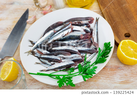 Pile of small raw fish is piled on plate, ready for frying. Pile of small raw fish is piled on plate, ready for frying. 139225424