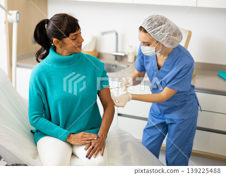 Female nurse vaccinating patient 139225488