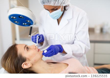 Woman receiving cosmetic facial injection at clinic Woman receiving cosmetic facial injection at clinic 139225535