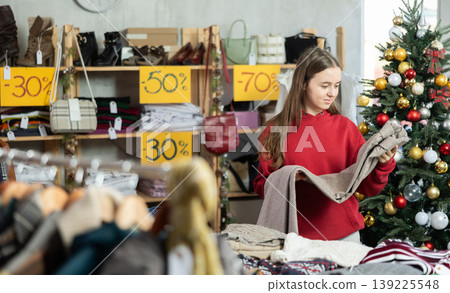 Teenage girl choosing trousers in clothing store Teenage girl choosing trousers in clothing store 139225548