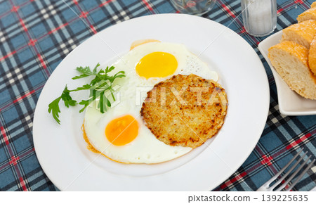 On plate are marrow squash pancakes with fried eggs 139225635