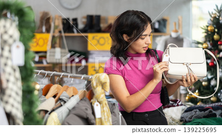 Filipino woman chooses a stylish handbag at Christmas sale Filipino woman chooses a stylish handbag at Christmas sale 139225695