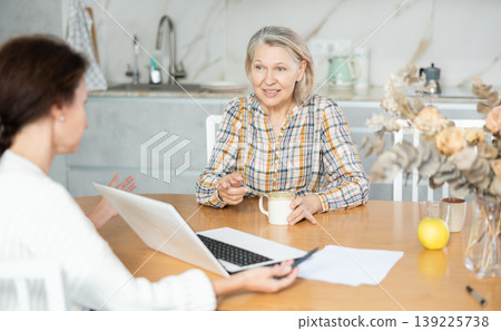 Real estate agent consulting elderly woman in home Real estate agent consulting elderly woman in home 139225738