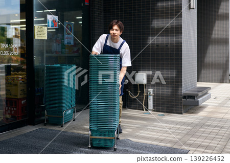 A store clerk organizing shopping baskets A store clerk organizing shopping baskets 139226452