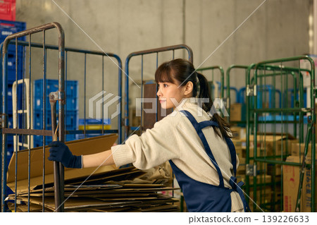 一位女士正在後屋整理紙箱。 一位女士正在後屋整理紙箱。 139226633