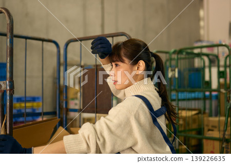 一位女士正在後屋整理紙箱。 139226635
