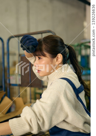 一位女士正在後屋整理紙箱。 139226636